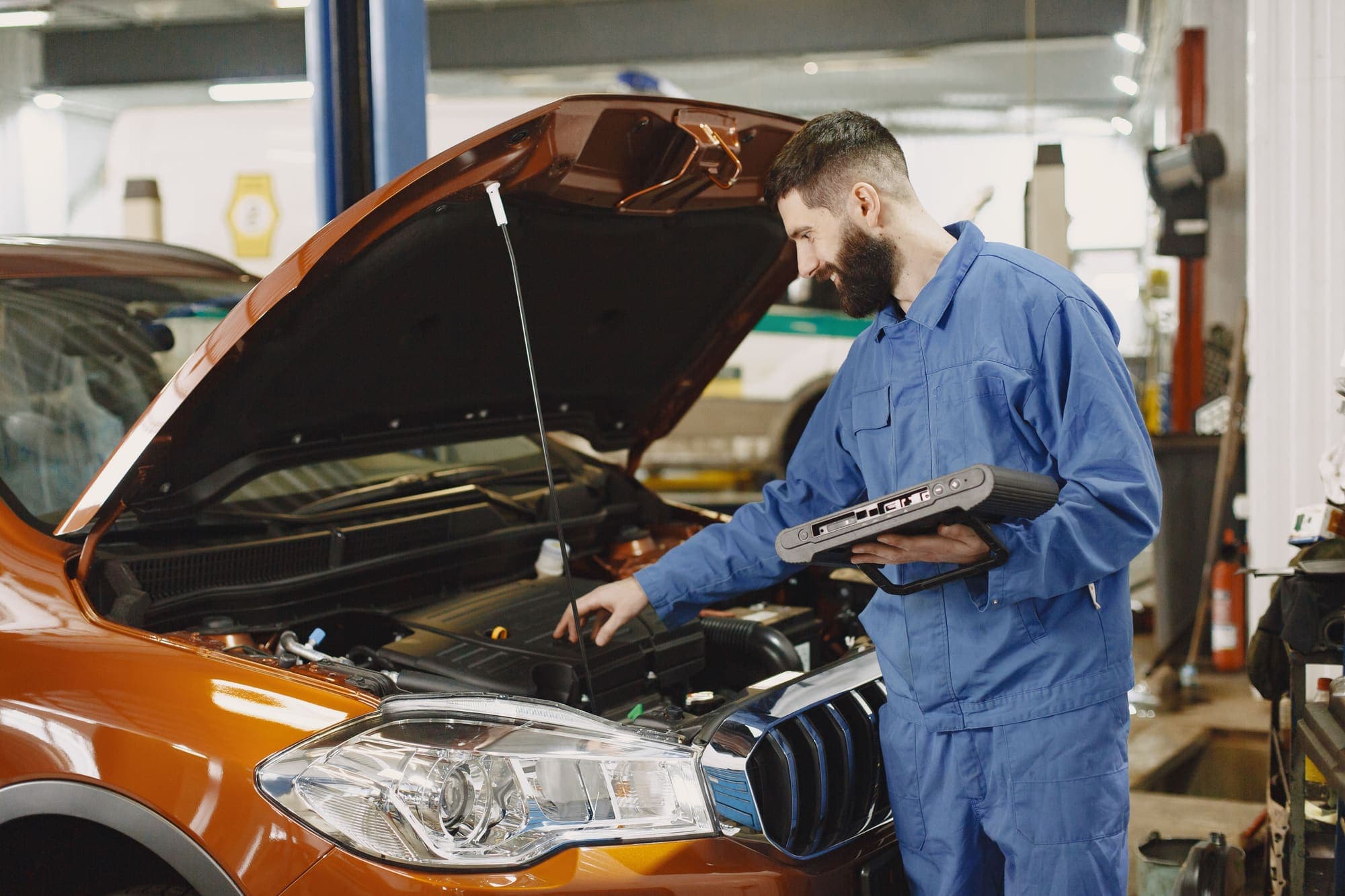 A technician working through a diagnostic session on a vehicle in a service bay.