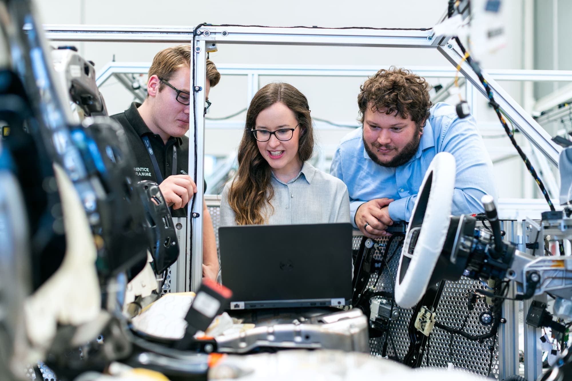 Automotive engineers reviewing technical documentation together in a workshop.
