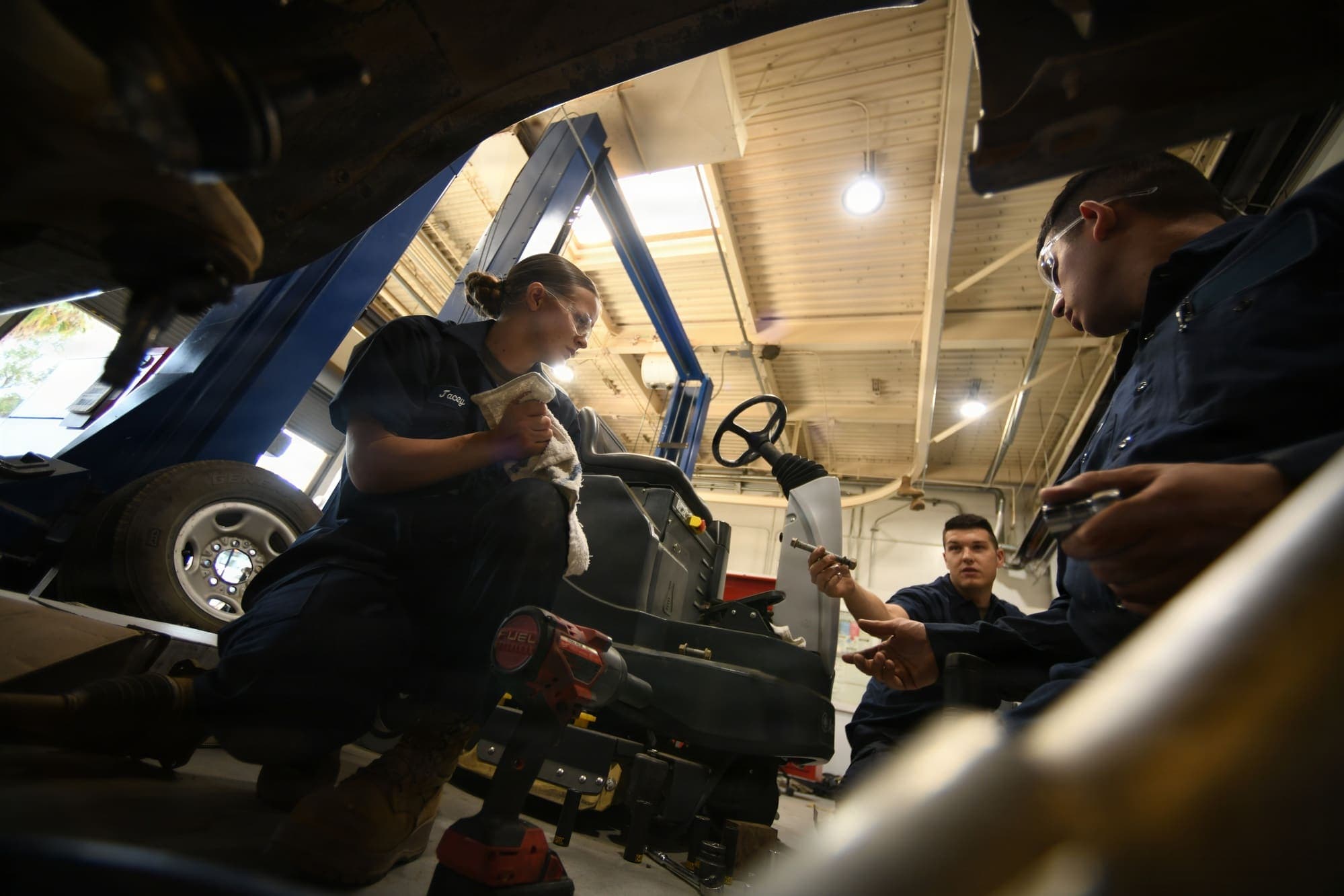 Automotive technicians following a hands-on training session in a workshop.
